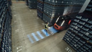 Das Assistenzsystem Linde Reverse Assist Radar im Einsatz. Ein Fußgänger läuft hinter dem Linde X30 entlang.