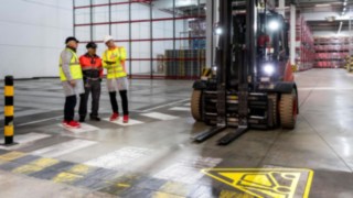 Beratungsgepräch mit mehreren Personen in der Werkshalle. Beratungsgepräch mit mehreren Personen in der Werkshalle.