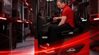 Seitenansicht eines Bedieners bei der Arbeit im ergonomischen Linde-MH-Schubmaststapler Ri16.