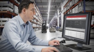 Umfassende Konnektivität garantiert, dass die Stapler in Flottenmanagement-Systeme und digitale Prozesse leicht integriert werden können. Person arbeitet an einem Computer